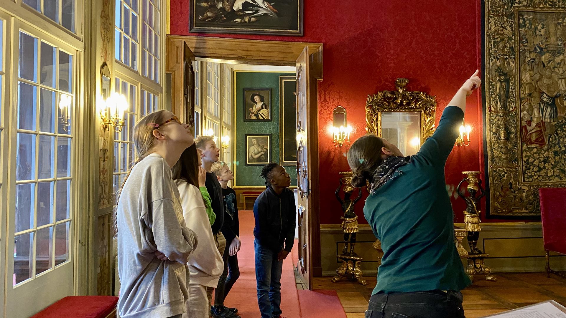 Im Schloss Museum zeigt eine Frau ein paar Schülern die Ausstellung.